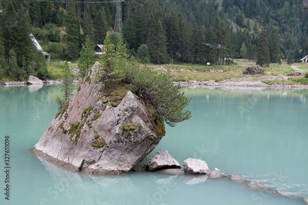 Obraz Big stone with trees in the middle of a turquoise Alpine lake