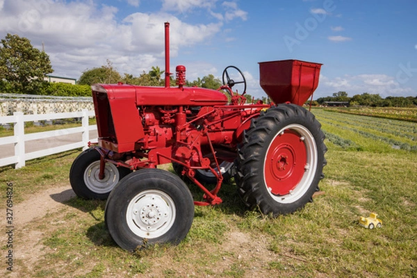 Fototapeta old red tractor in a field