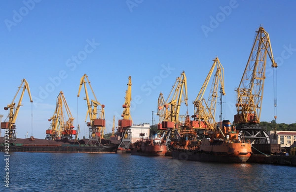 Fototapeta cranes in a port, unloading  ships