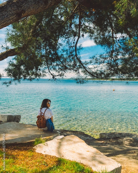 Fototapeta woman in white standing at the beach cliff with beautiful view of summer sea