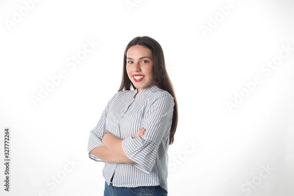 Fototapeta Brunette girl with arms crossed in front of the camera on a white background