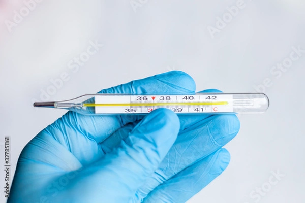 Obraz medical mercury thermometer in hand, means of protection from the cold and flu season