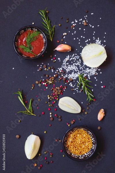 Fototapeta Various herbs and spices on dark background, top view