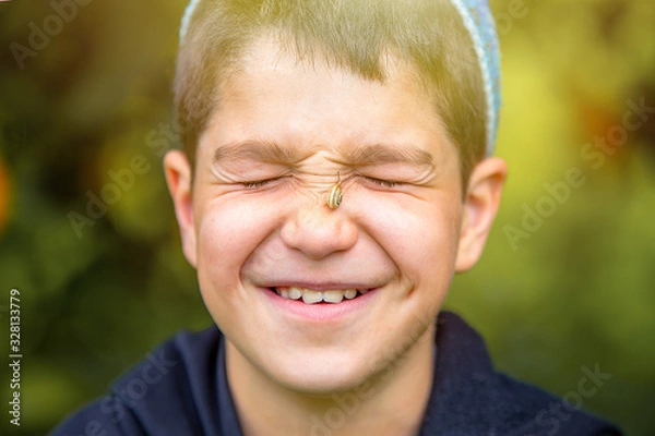 Fototapeta a boy in the sunlight with a snail on his face