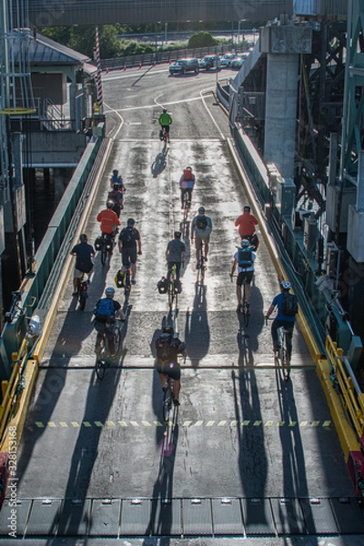 Obraz cyclist leaving ferry with shadows