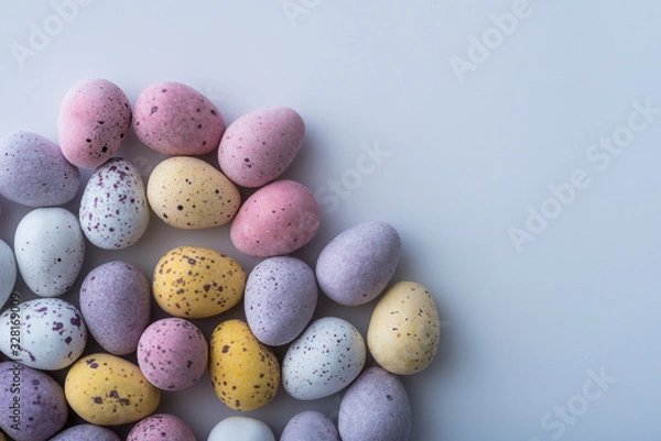 Fototapeta Colorful mini Easter eggs on a plain back ground with copy space