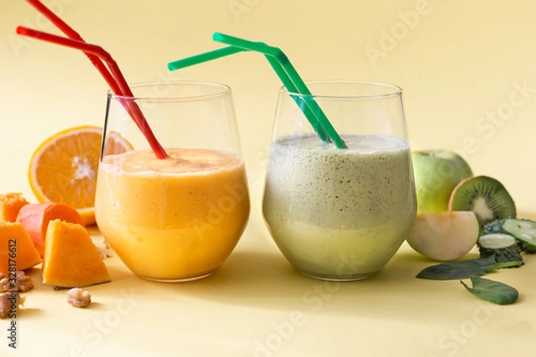 Fototapeta Two healthy vegetarian diet smoothies in glasses on a yellow background.