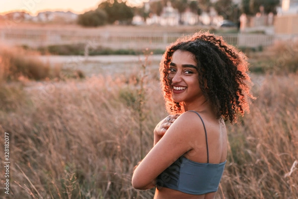 Obraz Smiling young black curly haired girl walking on the beach