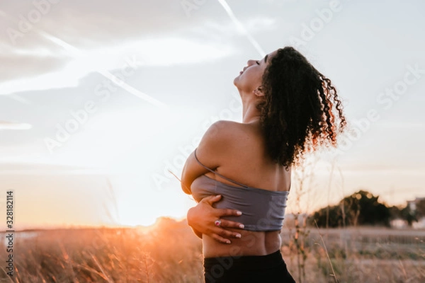 Obraz black girl hugging herself with the sky and the beach in the background
