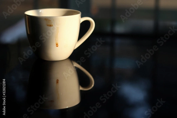 Obraz Coffee cup white color empty and dirty after drinking on the glass table. Reflection shadow of Coffee cup.