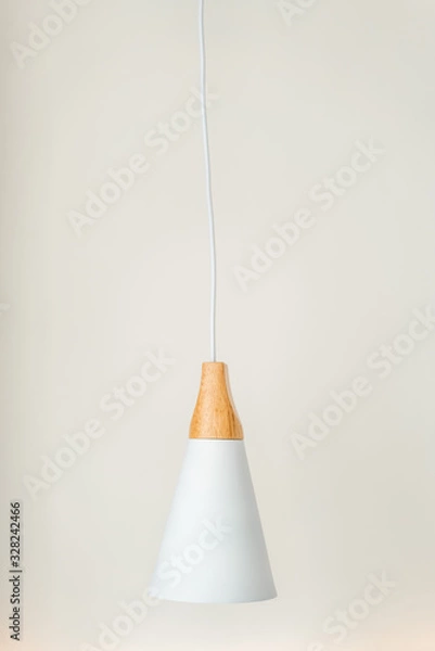 Fototapeta Close-up of vertical white pendant design by combined materials with oak wood and white painted metal, light hanging over white background.