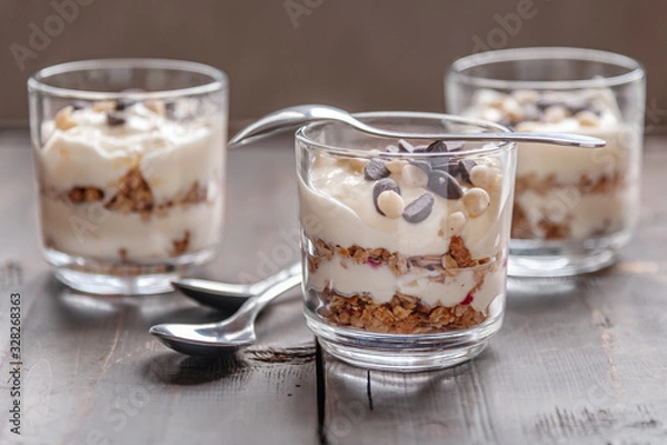 Fototapeta delicious layered dessert of muesli and fruit yogurt decorated with chocolate
