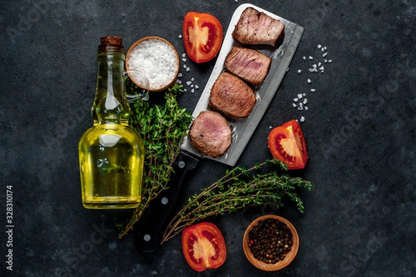 Fototapeta  Grilled beef steak over meat knife with spices. View from above. on a stone background. with copy space for your text