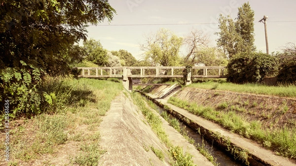 Fototapeta Stone Bridge Over Overgrown Canal 