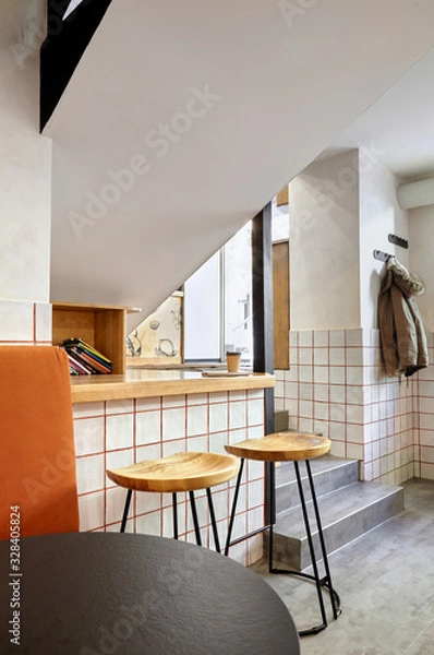 Fototapeta Stylish. Modern interior of cafe.Authentic style with element of loft.Round black and white tables,chairs and orange sofa..White tiles with orange lines.Orange,white and grey colors.