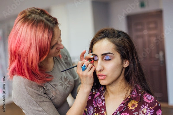 Fototapeta Make-up artist working with model in studio.