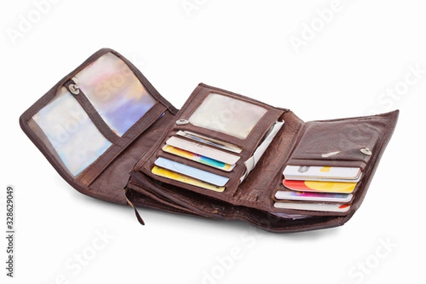 Fototapeta Typical open ladies wallet full of cards, pictures, books of receipts and other things. Isolated on white background with natural shadow. Leather purseful on white bg. Brown skin. Female wallet.