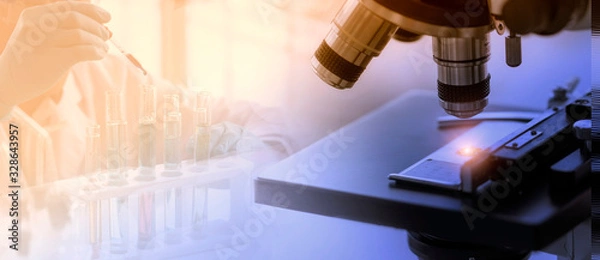 Fototapeta Laboratory concept; close up of microscope with a blurred picture of the scientist is researching in laboratory
