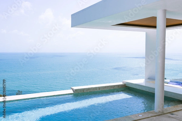 Fototapeta View of the villa and sea landscape with a blue pool in a minimalist style. Rich and luxurious life in the tropics of the island
