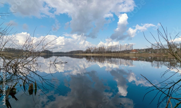 Fototapeta the view of the calm lake, the blue sky
