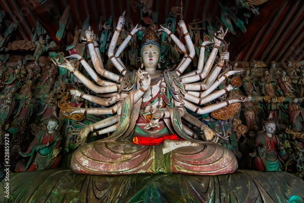 Obraz Fine ancient figure of buddhist goddess with 24 arms.  Altar statue made in wood located in Shuanglin Temple (or Zhongdu Temple), outskirts Pingyao Old City, Shanxi province, China