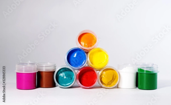Fototapeta Multi-colored gouache in plastic jars on a white background to create beautiful paintings