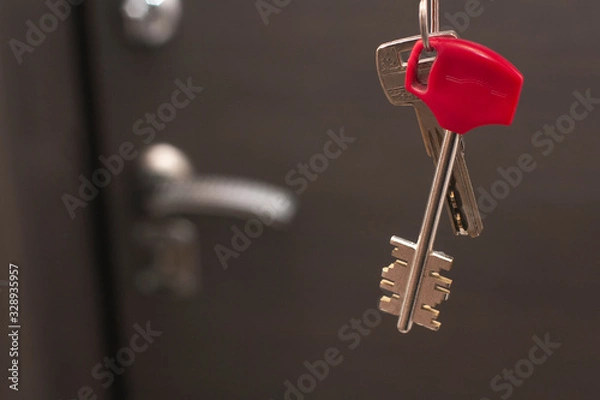 Fototapeta Door keys hanging in front of a closed door