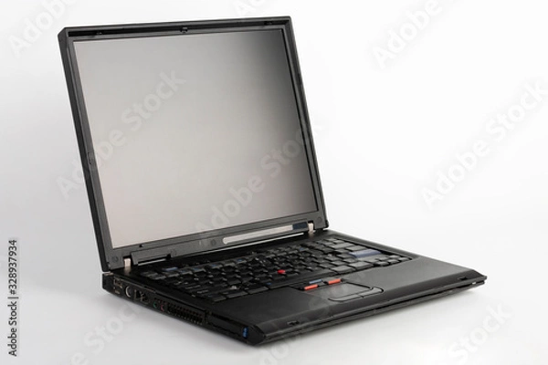 Fototapeta Old laptop on white background, which was produced in 2005, outer cover reinforced titanium, metal hinges, red trackpoint