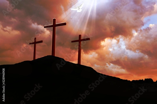 Fototapeta A dramatic red stormy sky above three crucifix silhouettes on a dark hill, with a break in the cloud and rays of light shining down