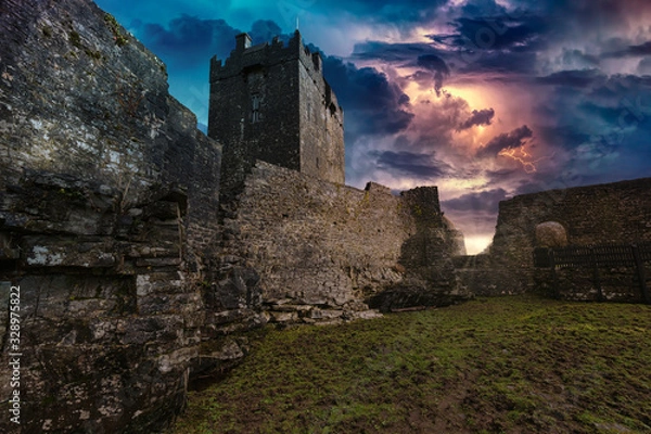 Fototapeta An ancient old castle in Ireland with a storm and lightning landscape