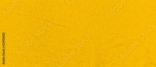 Fototapeta Vibrant yellow texture of binding fabric. Yellow textile background with natural folds. Close-up