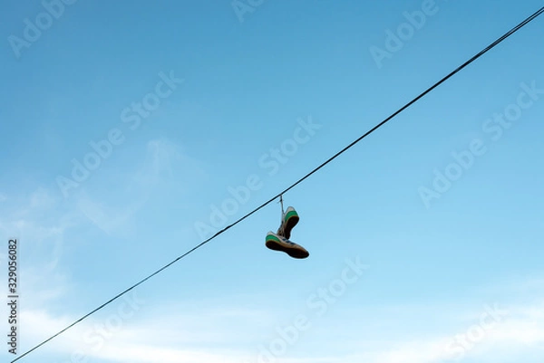 Obraz sneakers hung on an electric cable