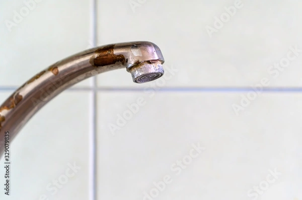 Obraz Old rusty drinking tap with a drop of water on a light background close-up. 