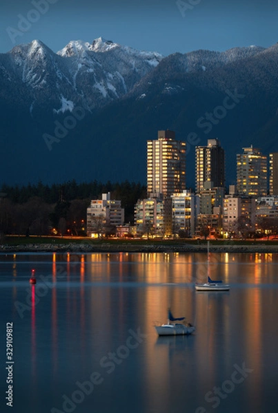 Fototapeta Vancouver West End Dusk. Sailboats anchored in English Bay. In the background are the snowcapped North Shore Mountains. Vancouver, British Columbia, Canada.