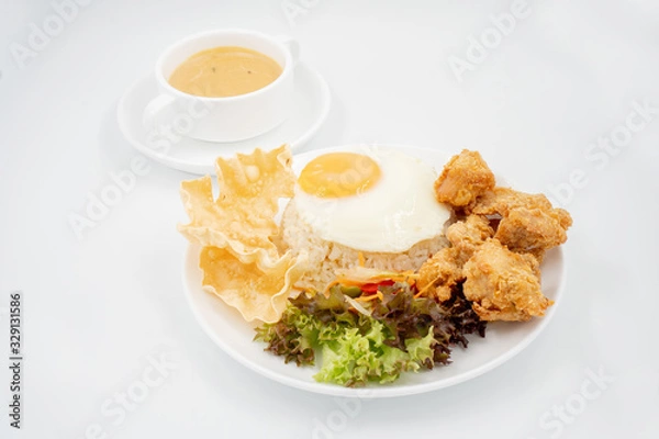 Fototapeta Buttermilk chicken rice with ingredients isolated on white with fried egg and salad.