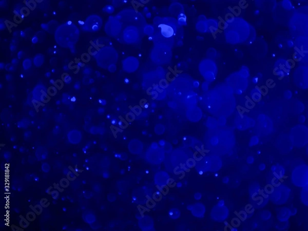 Fototapeta Abstract blue bokeh texture on black background.