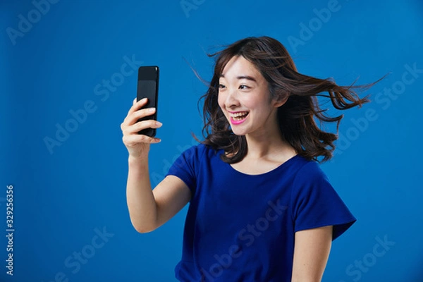 Fototapeta スマートフォンを持って驚く女性