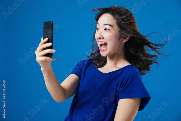 Fototapeta スマートフォンを持って驚く女性