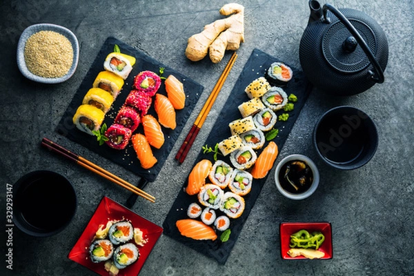 Fototapeta apanese sushi food. Maki ands rolls with tuna, salmon, shrimp, crab and avocado. Top view of assorted sushi. Rainbow sushi roll, uramaki, hosomaki and nigiri