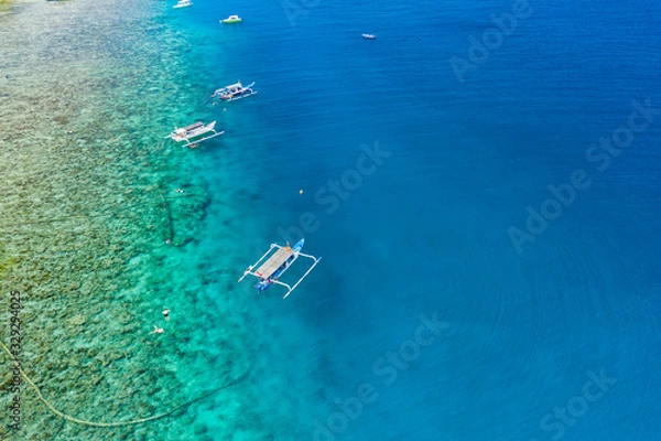 Fototapeta Aerial drone view of snorkelers and boats above a coral reef in a clear, tropical ocean
