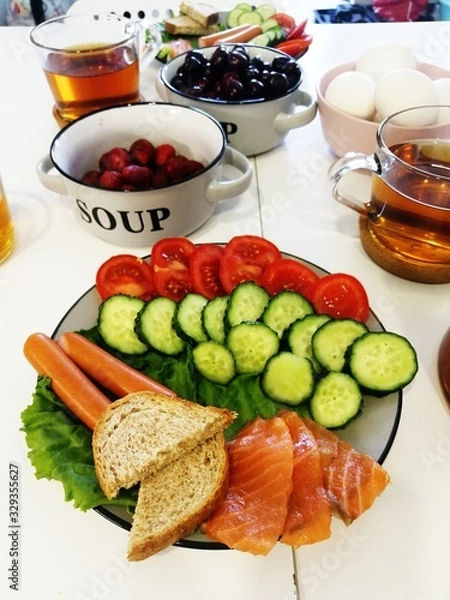 Obraz Sausages with vegetables for breakfast. Cucumber and croutons on a plate