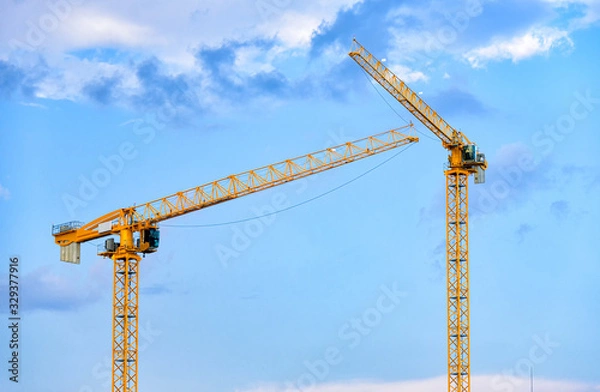 Obraz Construction cranes over blue sky