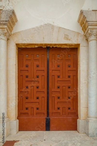 Obraz Large orange cathedral doors with white columns. Entrance to the church St. Louis in Carthage, Tunisia