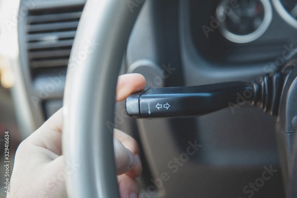 Obraz Driver using turn signal control light in car