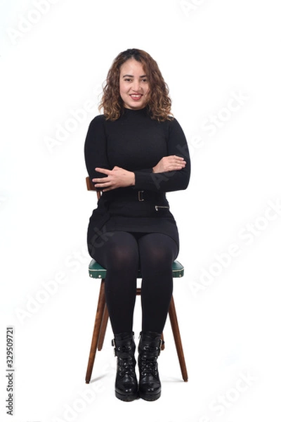 Fototapeta portrait of a woman sitting on a chair in white background, arms crossed