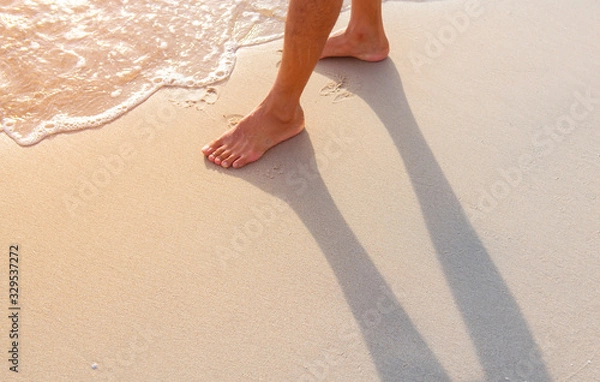 Fototapeta The man was walking happily in the sea at dawn