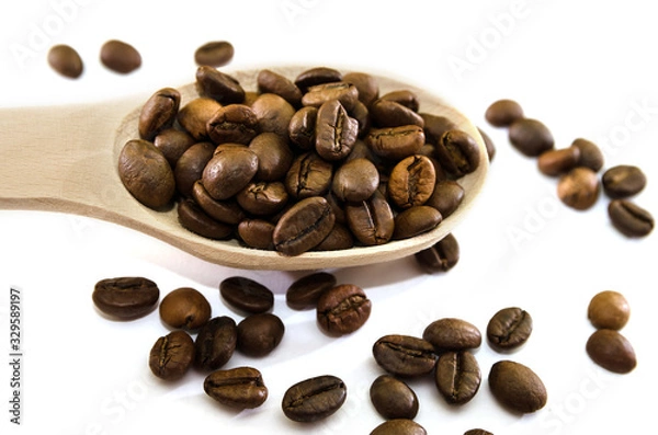 Fototapeta roasted coffee beans in a wooden spoon on a white background. View from above. Close-up.