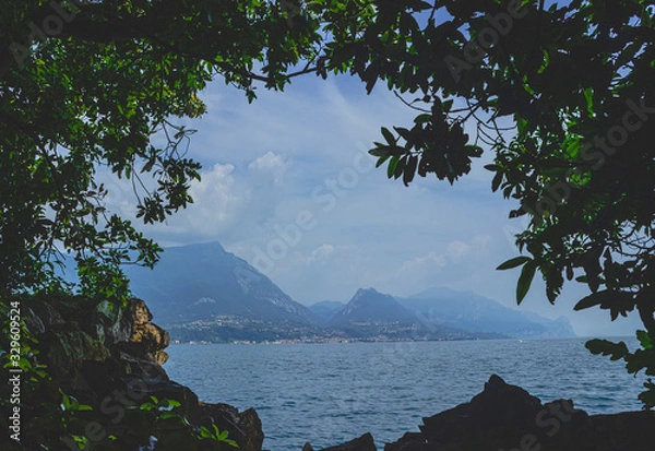 Obraz View of lake Garda from the shadow of the Park . Misty coast in the background. Italy. Soft focus, blurry background.
