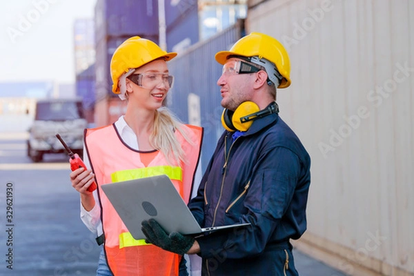 Fototapeta Worker man and woman discuss about their system and express happy emotion in cargo container shipping area.