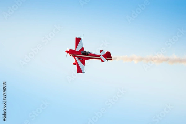 Fototapeta Acrobatic airplane in the sky with smoke signal